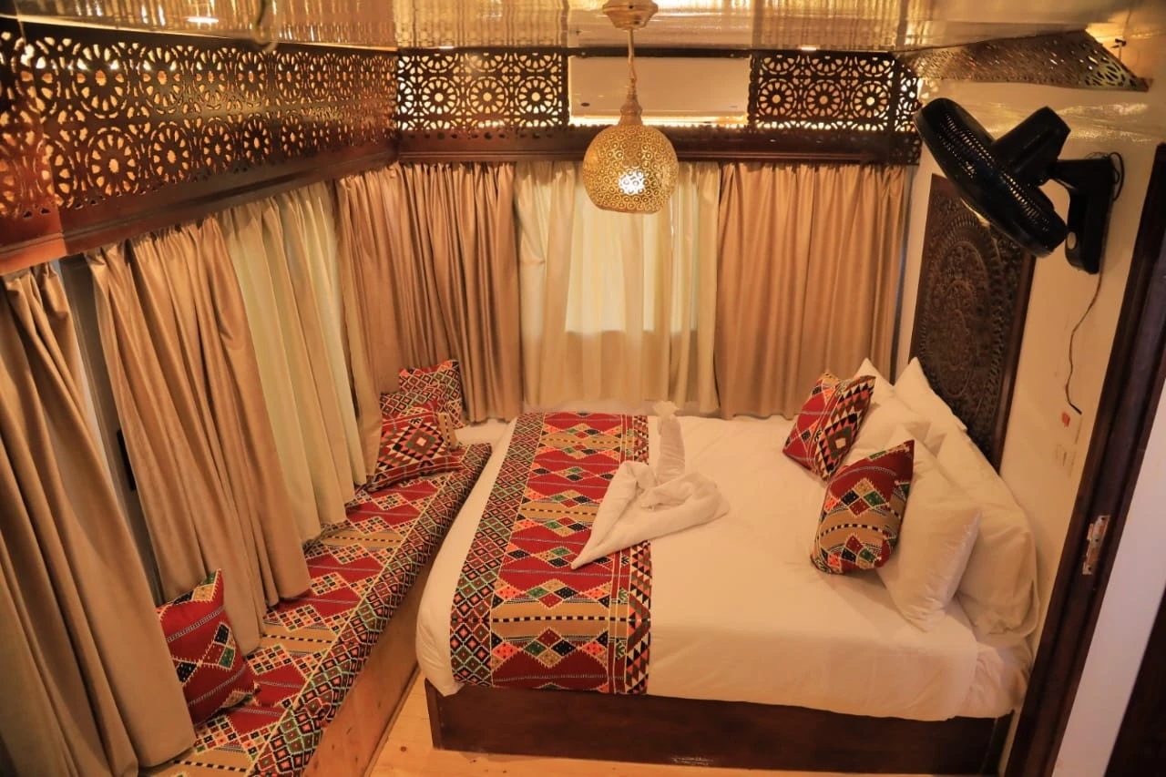 Elegant bedroom inside Queen Nefer Dahabiya Cruise cabin