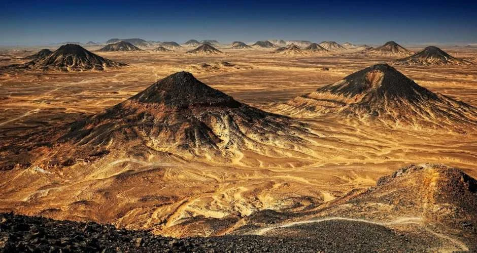 Black Desert Egypt with dark volcanic mountains and sand