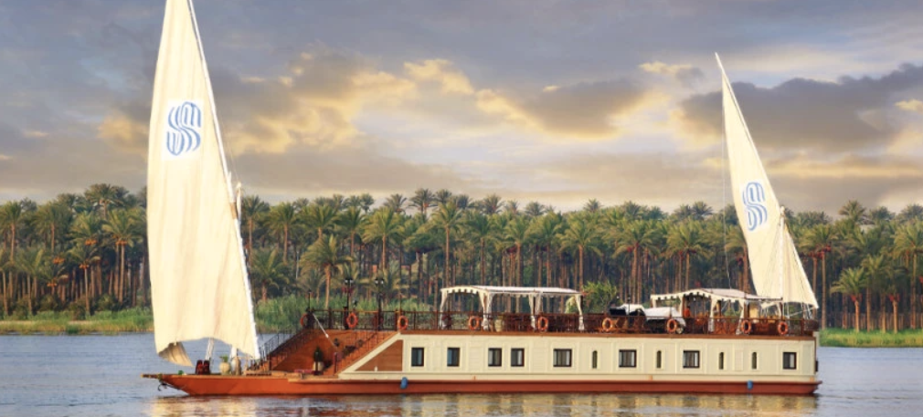 A picture of a beautiful Dhabaya in the Nile River with some natural trees as a background